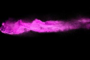 Pink dust particle splash on black background.Pink powder splash. photo