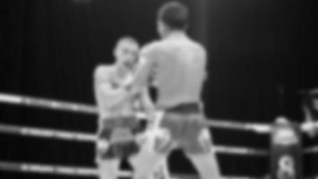 imágenes borrosas estilo fotográfico en blanco y negro de boxeo tailandés o muay thai o kickboxing que boxeador local y extranjero están luchando en el ring en el escenario interior como deporte de arte marcial. kickboxing muay thai foto