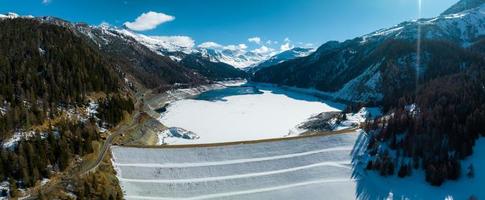 Aerial view of the water dam and reservoir lake in Swiss Alps mountains producing sustainable hydropower photo