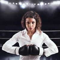 Determined businesswoman with boxing glove photo