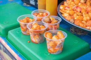 pescado albóndigas servido en el plastico tazas y vendido a culinario festivales, tradicional mercado meriendas. japonés comida es llamado chikuwa foto