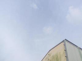 the corner of the roof of the building with the background of a clear blue sky photo