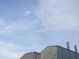 factory building with chimney tower against clear and blue sky background photo