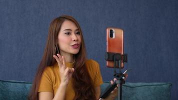 asiatique femmes la vie entraîneur vidéo appel avec élèves à suggérer Succès affaires façon. Jeune entrepreneur diffusion dans social médias, liberté et actif mode de vie concept, communiquer Ventes via vivre vidéo. video