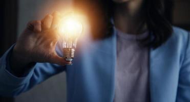 woman Hand holding Light bulb Global Internet connection. Business global internet connection application technology and digital marketing, Financial and banking, Digital link tech, big data. photo