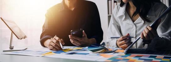 Close up ux developer and ui designer brainstorming about mobile app interface wireframe design on table with customer breif and color code at modern office.Creative digital development agency photo