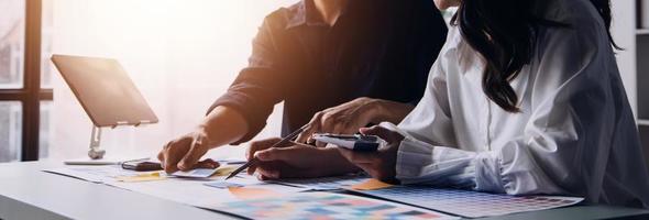 Close up ux developer and ui designer brainstorming about mobile app interface wireframe design on table with customer breif and color code at modern office.Creative digital development agency photo