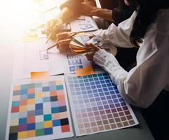 Close up ux developer and ui designer brainstorming about mobile app interface wireframe design on table with customer breif and color code at modern office.Creative digital development agency photo