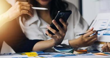 Close up ux developer and ui designer brainstorming about mobile app interface wireframe design on table with customer breif and color code at modern office.Creative digital development agency photo