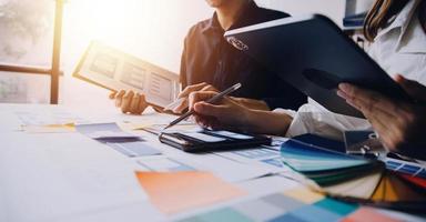 Close up ux developer and ui designer brainstorming about mobile app interface wireframe design on table with customer breif and color code at modern office.Creative digital development agency photo