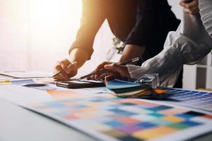 Close up ux developer and ui designer brainstorming about mobile app interface wireframe design on table with customer breif and color code at modern office.Creative digital development agency photo