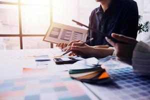 Close up ux developer and ui designer brainstorming about mobile app interface wireframe design on table with customer breif and color code at modern office.Creative digital development agency photo