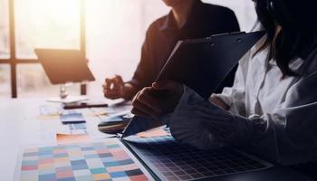 Close up ux developer and ui designer brainstorming about mobile app interface wireframe design on table with customer breif and color code at modern office.Creative digital development agency photo