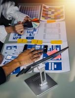 Close up ux developer and ui designer brainstorming about mobile app interface wireframe design on table with customer breif and color code at modern office.Creative digital development agency photo