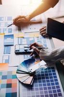 Close up ux developer and ui designer brainstorming about mobile app interface wireframe design on table with customer breif and color code at modern office.Creative digital development agency photo