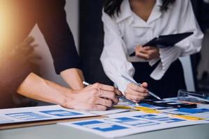 Close up ux developer and ui designer brainstorming about mobile app interface wireframe design on table with customer breif and color code at modern office.Creative digital development agency photo