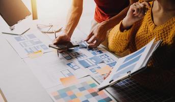 Close up ux developer and ui designer brainstorming about mobile app interface wireframe design on table with customer breif and color code at modern office.Creative digital development agency photo