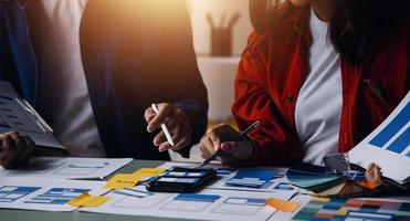 Close up ux developer and ui designer brainstorming about mobile app interface wireframe design on table with customer breif and color code at modern office.Creative digital development agency photo