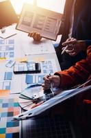 Close up ux developer and ui designer brainstorming about mobile app interface wireframe design on table with customer breif and color code at modern office.Creative digital development agency photo