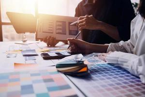 Close up ux developer and ui designer brainstorming about mobile app interface wireframe design on table with customer breif and color code at modern office.Creative digital development agency photo