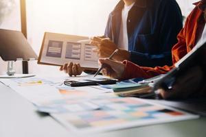 Close up ux developer and ui designer brainstorming about mobile app interface wireframe design on table with customer breif and color code at modern office.Creative digital development agency photo