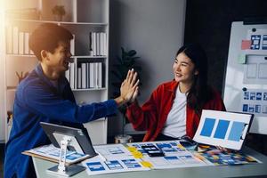 Close up ux developer and ui designer brainstorming about mobile app interface wireframe design on table with customer breif and color code at modern office.Creative digital development agency photo