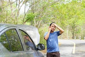 man called a mechanic to come look at the broken car. photo