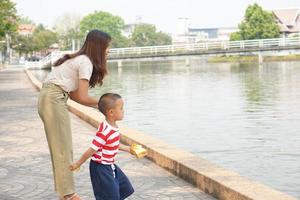 mother and son feeding birds in the park photo