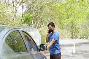 man called a mechanic to come look at the broken car. photo