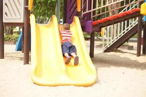 boy playing in the playground in the park photo