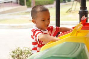 Boy looking at trash cans in the garden photo