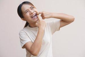 Asian woman with food scraps stuck in her teeth photo