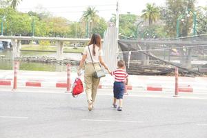madre toma su niño a caminar a través de el calle. foto
