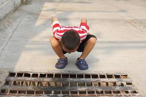 boy looking through the sewer photo