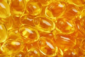 Primer plano de cápsulas doradas de vitamina omega 3 aceite de pescado foto