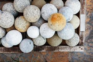 Marble cannonballs of gray color in a basket, top view. photo