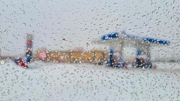 At a gas station in winter, rain drops through the car window photo