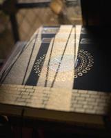 Quran or Kuran the islamic holy book on sun shine black background . Ramadan background, photo