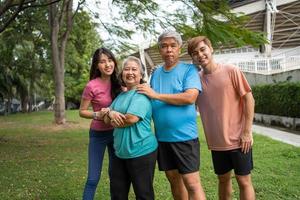 Healthy family group instructors workout in fresh air, and they rest and stand together after morning exercises in park. Outdoor activities, healthy lifestyle, strong bodies, fit figures, health care. photo