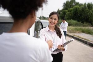 Women drivers Talk to Insurance Agent for examining damaged car and customer checks on the report claim form after an accident. Concept of insurance, advice auto repair shop and car traffic accidents.