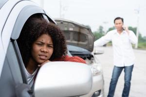 Asian women drivers sit in car for waiting insurance after check for damage after car accident, taking pictures to send insurance. Online car accident insurance claim after send photos to insurance.