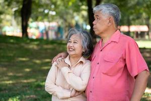 Portrait of lovely elderly couple hugging each other with love and happiness in a park outdoor. Happy smiling Elderly couple enjoying with positive emotions at garden photo