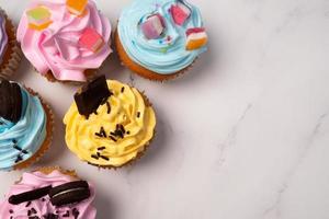 deliciosos cupcakes caseros con crema de colores y cobertura con dulces y galletas de chocolate. postre casero de vacaciones de otoño foto