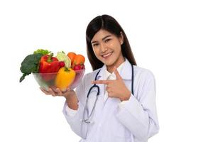 médico o nutricionista con fruta fresca naranja, manzanas rojas y verdes y sonrisa en la clínica. concepto de dieta saludable de alimentos nutritivos como receta para una buena salud, la fruta es medicina foto