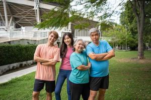 Healthy family group instructors workout in fresh air, and they rest and stand together after morning exercises in park. Outdoor activities, healthy lifestyle, strong bodies, fit figures, health care. photo