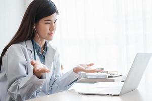 Asian therapist woman doctor is online visiting with a patient on the internet application. Her Listening and Give advice and explains how to treat the initial disease, Concept of Medical technology. photo