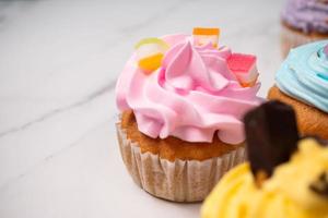 deliciosos cupcakes caseros con crema de colores y cobertura con dulces y galletas de chocolate. postre casero de vacaciones de otoño foto