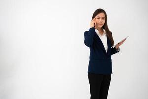 Portrait of happy young thoughtful Asian women think for new ideas and holding tablet on isolated white background. Concept of advertising marketing and product placement. photo