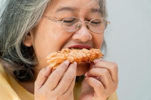 Happy Asian senior women enjoying eating pie photo