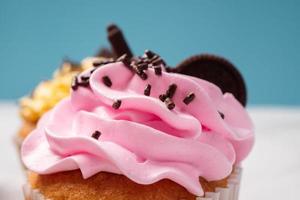 deliciosos cupcakes caseros con crema de colores y cobertura con dulces y galletas de chocolate. postre casero de vacaciones de otoño foto